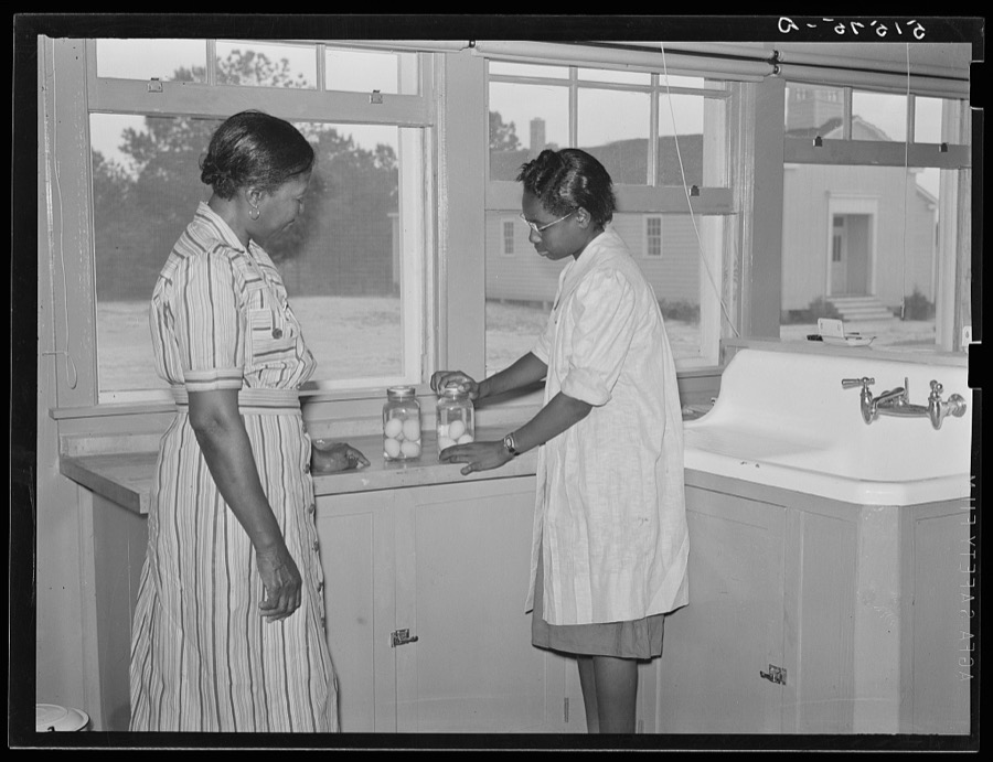 Juanita Coleman, NYA (National Youth Administration) leader and teacher, helps Sally Titus preserve some eggs. Through this activity the girl has bought some badly needed eyeglasses. Gee's Bend, Alabama