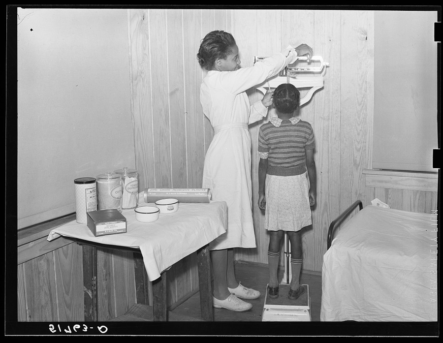 Child being weighed and examined in health room. Prairie Farms, Alabama
