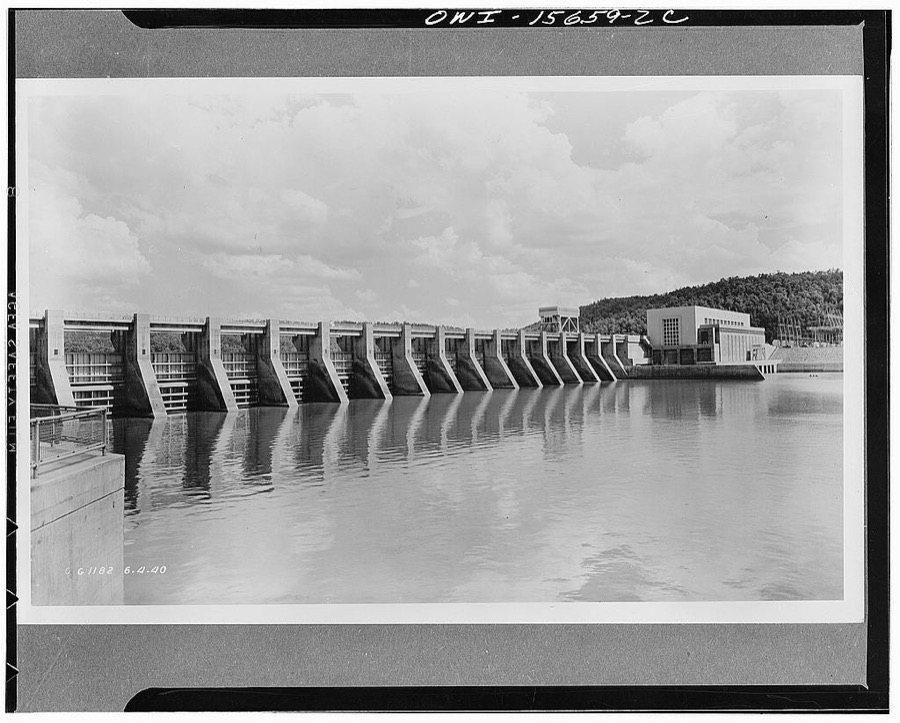 Guntersville Dam and powerhouse. General view of spillway and powerhouse. The latter encloses three units, is intended to extend eventually to a fourth. Note one of two traveling gantry cranes on spillway deck. Main generator hall built in brick because it is in flood-proof portion; downstream bay which houses control equipment in lower stories and offices above is in concrete on account of flood hazard