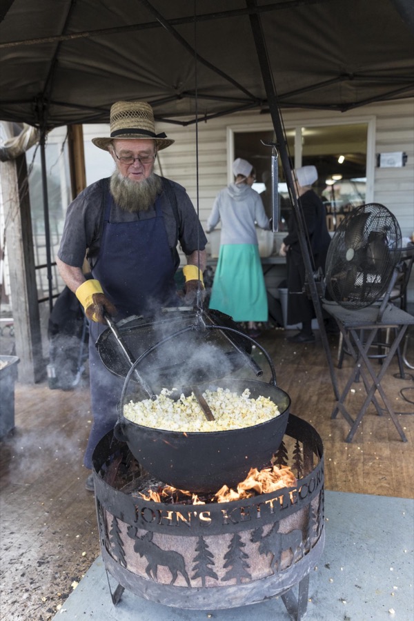 An Amish man tends to popcorn, prepared over an open fire at Hershberger's Farm and Bakery, a greatly expanded produce stand near the town of Berlin in central Ohio's "Amish Country"