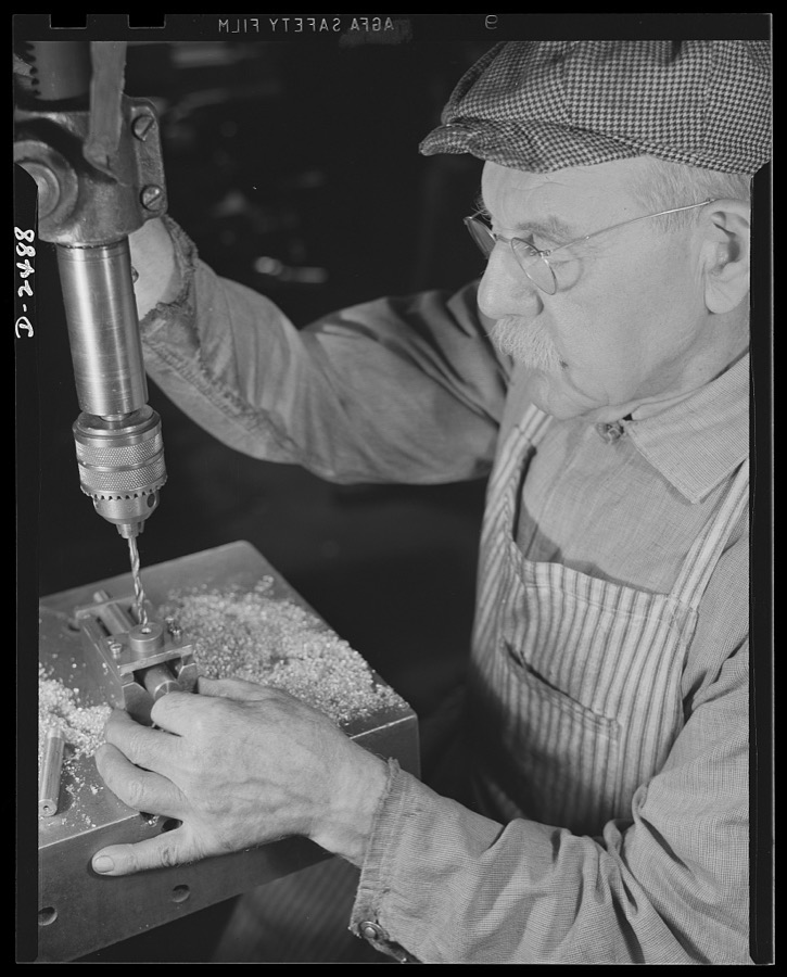 Conversion. Food machinery plant. Back to aid in his country's war effort is Phineas Davenport Allen, seventy-eight-year-old mechanic who worked on steering riggings for submarines during World War I. Today he is employed by a New England company, whose normal peacetime product is cube steak machinery. The drill press he operates was a valuable part of the company's peacetime equipment, is even more valuable today in the speeding of work on war subcontracts. New tooling and a large drill have fitted this press for the drilling of screw machine parts needed in new machine tools for war production. Cube Steak Machine Company, Boston, Massachusetts