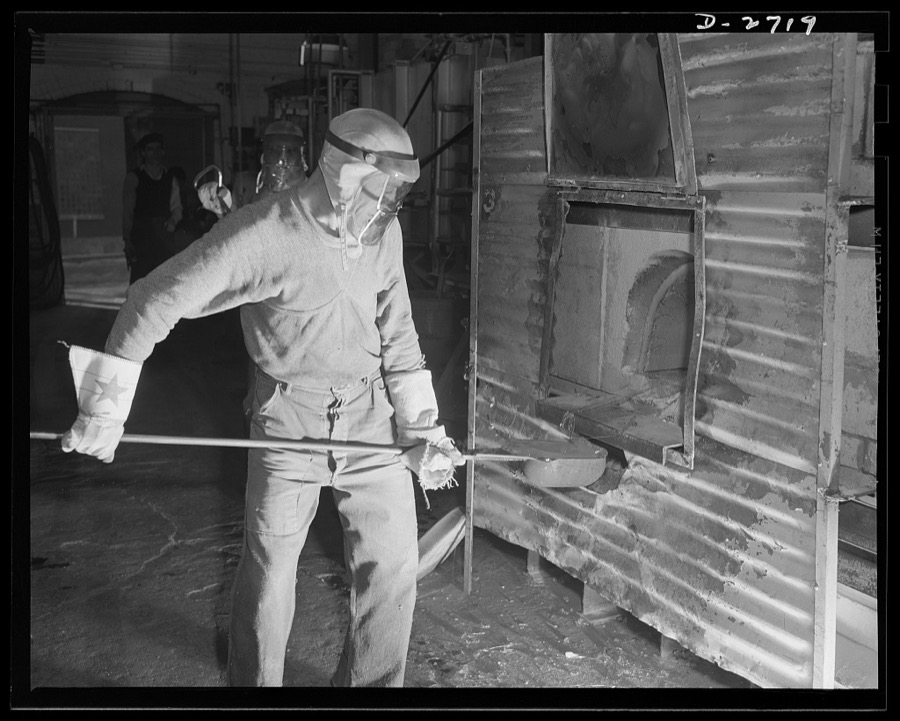 Fiberglass manufacture, Owens-Corning, Toledo, Ohio. This worker is ladling white-hot molten glass from a furnace in a plant of the Owens-Corning Fiberglass Corporation. When viscosity of the molten glass is at the point required by rigid quality control specifications, it will be used to form glass marbles from which glass yarns are drawn in another operation