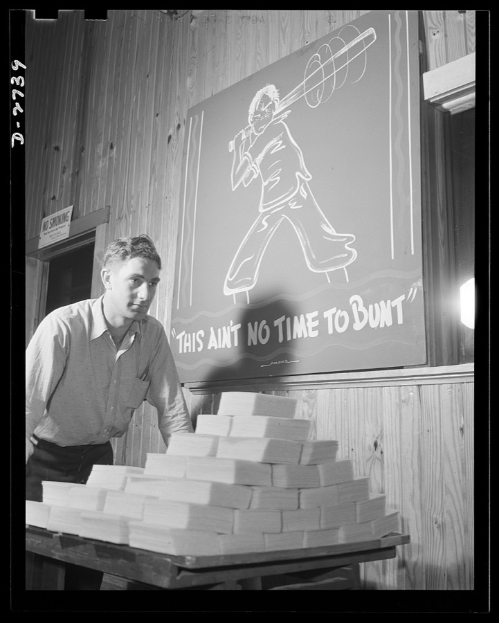 Fiberglass manufacture, Owens-Corning, Toledo, Ohio. "This is ain't no time to bunt." And this workman at a plant of Owens-Corning Fiberglass Corporation is batting out a hit by speeding carefully inspected packs of fiberglass retainer mats to the shipping department. These are supplied under Army and Navy specifications for storage batteries, to be used in submarines, tanks, and rough-riding reconnaisance cars