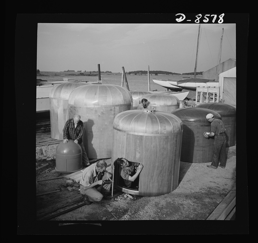 Conversion. Rowing shells to life rafts. Though they look like satin cushions, these smoothly sanded instrument protectors are made from plywood. Exact purpose of the covers is a military secret. Workers in the foreground are fitting the door on a completed protector