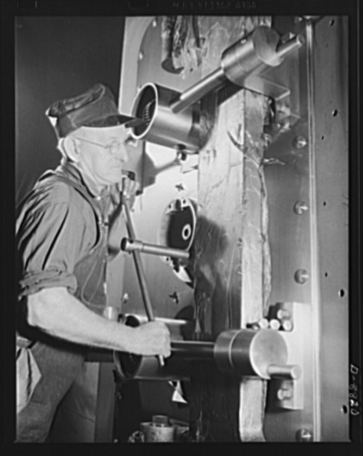 Production. Halftrac armoured cars. A mechanic at an Eastern lock and safe manufacturing plant assembles one of the last safe doors to be made there as all plant facilities are converted to the production of bodies for halftrac scout cars. Diebold Safe and Lock Company, Canton, Ohio