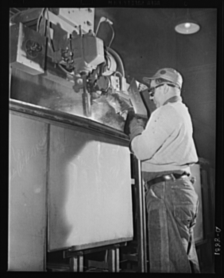 Production. Halftrac armoured cars. An arc welder joins parts of the body of a halftrac scout car in the converted Eastern plant of a lock and safe manufacturer. Diebold Safe and Lock Company, Canton, Ohio
