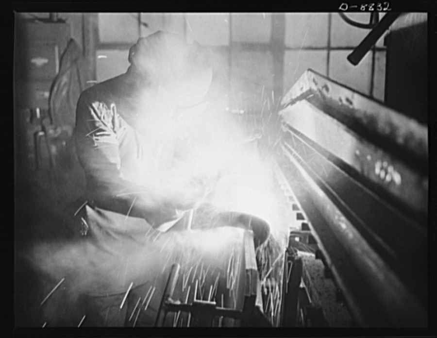 Production. Halftrac armoured cars. An arc welder joins parts of the body of a halftrac scout car in the converted Eastern plant of a lock and safe manufacturer. Diebold Safe and Lock Company, Canton, Ohio
