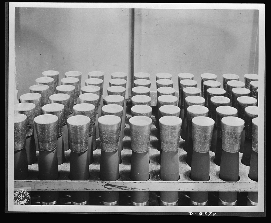 Production. Shell loading. TNT is poured into shells through these funnels on a distribution line in a large Midwest loading plant. TNT, used almost exclusively in shells, looks like a good grade of maple sugar. It is believed that soon the United States will use only TNT in bombs also. Ravenna ordnance plant