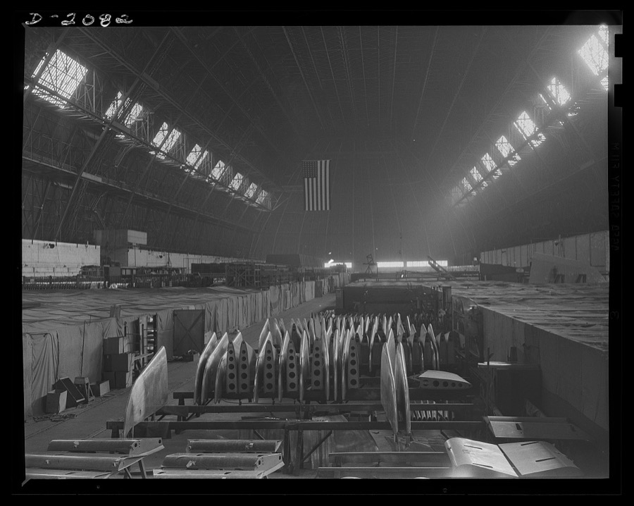 Subcontracting aircraft parts. The entire floor space of this huge Ohio plant is devoted to the manufacture of airplane parts. Working areas are covered with canvas so that they may be individually heated. It is not possible to heat the entire air volume of the building, which approximates 45,000,000 cubic feet. Goodyear, Akron, Ohio