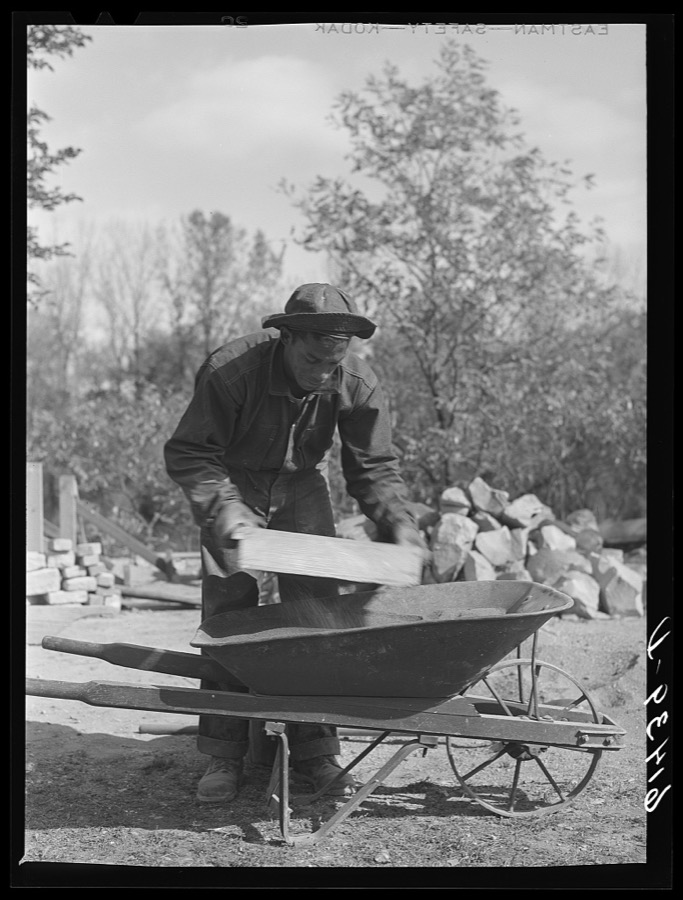 CCC (Civilian Conservation Corps) boy chopping stone for use in building charcoal burners at picnic grounds. Ross County, Ohio, recreation area