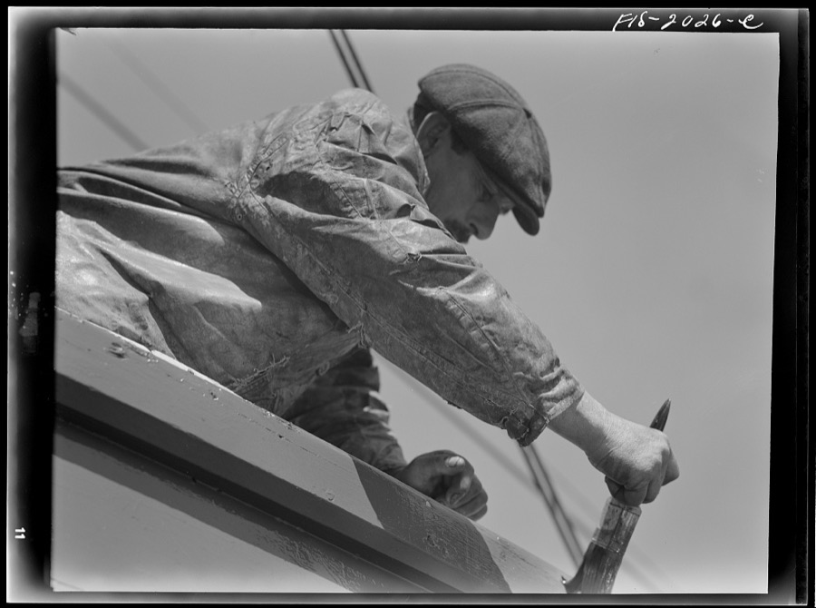 Provincetown, Massachusetts. The crew of the Frances and Marion, a Portuguese trawler, painting ship on the beach