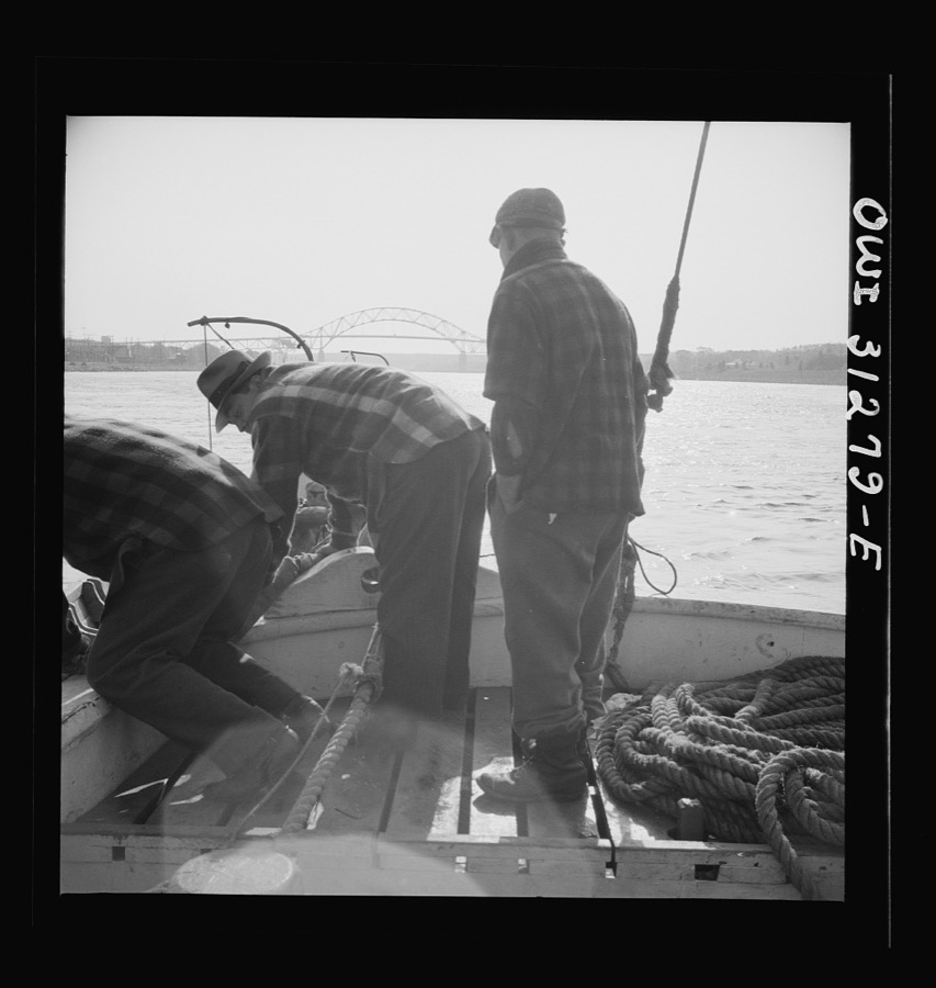 On board the fishing boat Alden out of Gloucester, Massachusetts. Fishermen sitting about the deck on the first morning