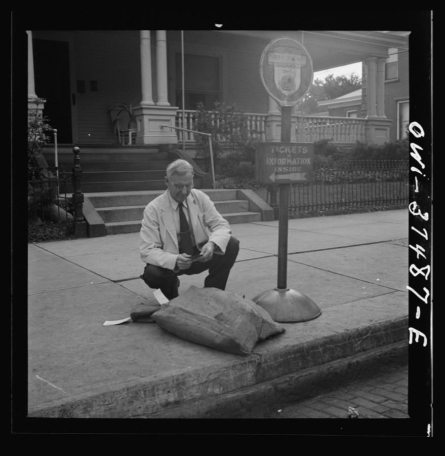 Washington Court House, Ohio. A ticket agent inspecting some freight left by a bus