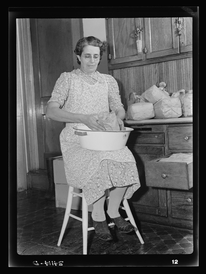 [Mrs. Albert Yaeger] storing home-dried [apples or corn] in sugar sacks