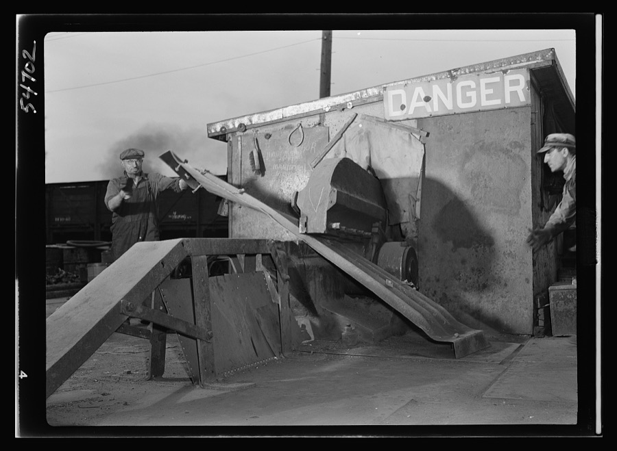 Boston and Maine railroad shops at Billerica, Massachusetts. The heavy sections of steel which were once proud boxcars but now fit only for scrap are being cut by these heavy shears so as to be made ready for shipping to steel mills