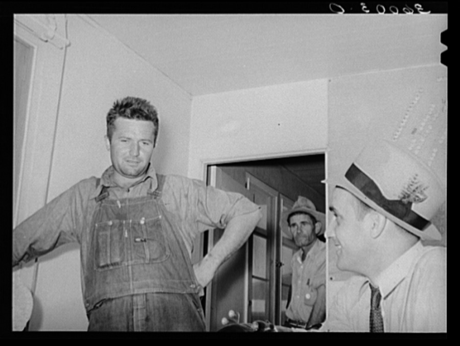 FSA (Farm Security Administration) regional official interviewing man who is interested in living in one of the permanent agricultural laborers' homes at the Aqua Fria migratory labor camp. Arizona