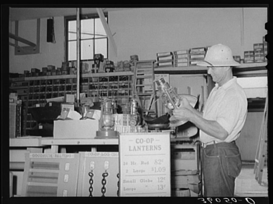 Member of the United Producers and Consumers Cooperative looking at a lantern in the store of the organization. Phoenix, Arizona