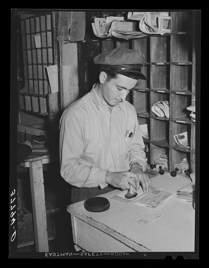 Postmaster cancelling stamps. Concho, Arizona
