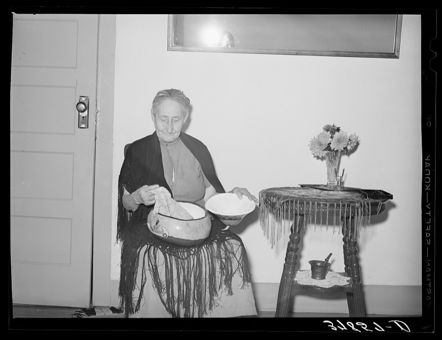 Woman of Spanish extraction looking at some crochet which she made. Concho, Arizona