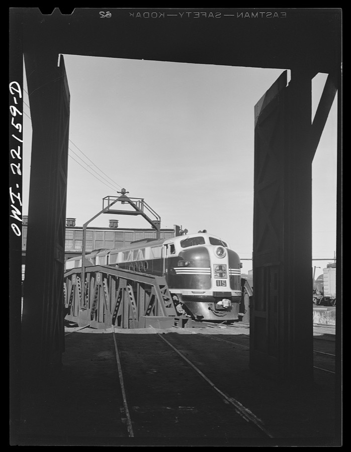 Winslow, Arizona. Atchison, Topeka, and Santa Fe Railroad diesel freight engine coming out of the roundhouse. The entire engine consists of four units, only two of which can be accomodated in a stall at the roundhouse or on the turntable