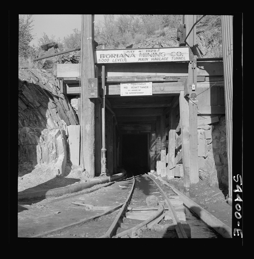 Kingman (vicinity), Arizona. A miner going toward a train of mine cars at the entrance of the Boriana mining company. These cars carry tungsten ore to a concentrating plant in the same area. The mine is about forty miles from Kingman