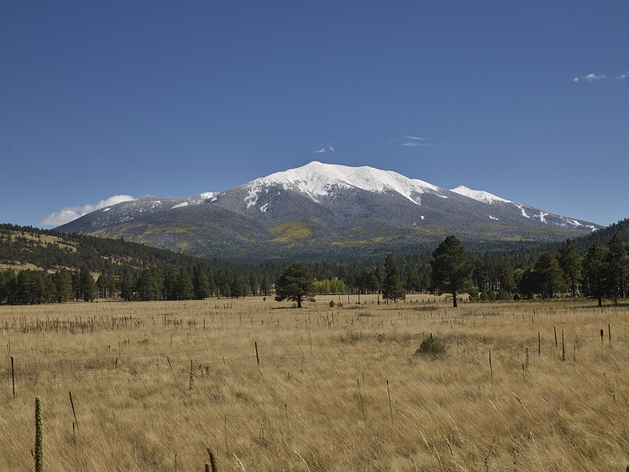 Scene within the highland and high-desert terrain of northern Arizona, above the city of Flagstaff. Looming in the distance is snow-covered Humphreys Peak, the highest natural point in Arizona, within a group of dormant volcanic crests known as the San Francisco Peaks