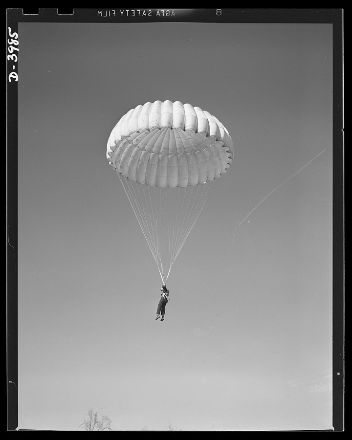 Fort Benning. Parachute troops. Look at that boy come, riding a chute like an oldtimer. A student paratrooper at Fort Benning, Georgia has wind currents to think about, and he has his mind on the spot where he wnats to land. He's learning to make the kind of a landfall he wants