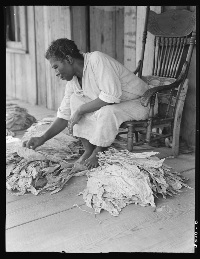 Near Douglas, Georgia. "You don't have to worriate so much and you've got time to raise somp'n to eat." The program to eliminate the risk and uncertainty of a one-crop system meets the approval of this sharecropper. She sits on the porch and sorts tobacco