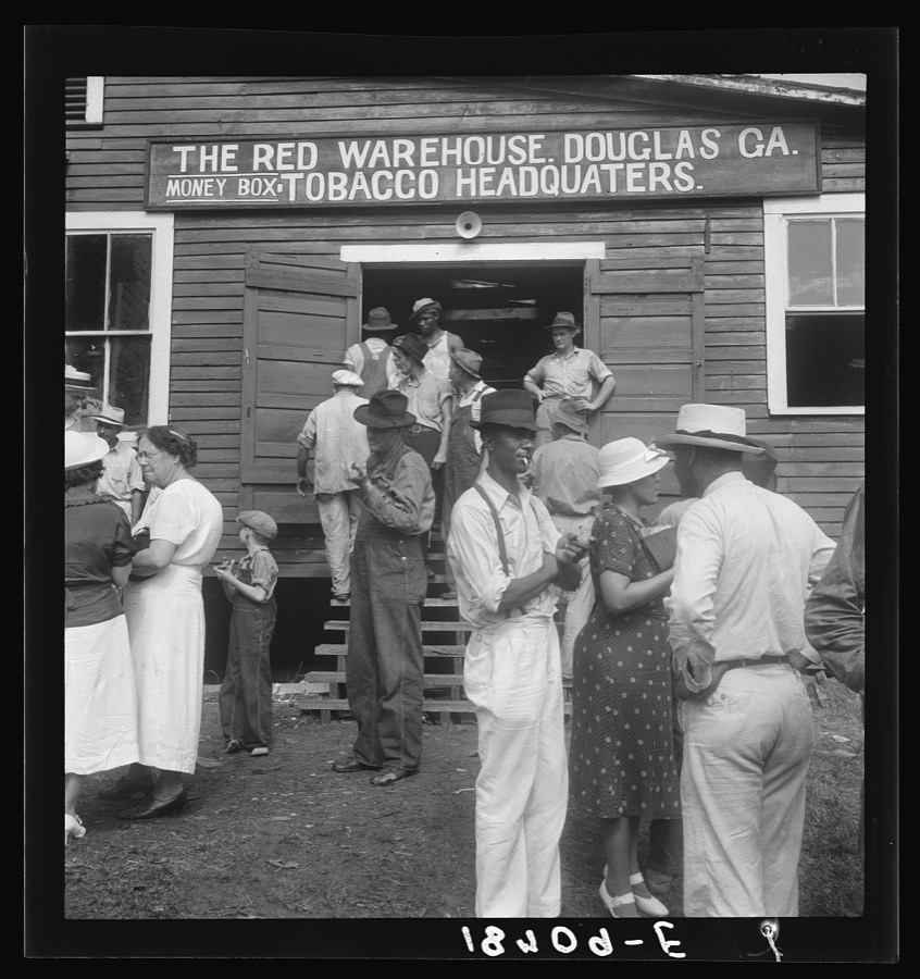 As the auctioneer knocks down the last bid on each basket of tobacco in the warehouse, the price is immediately recorded, and the farmers go to the "money box" to get their money. Douglas, Georgia