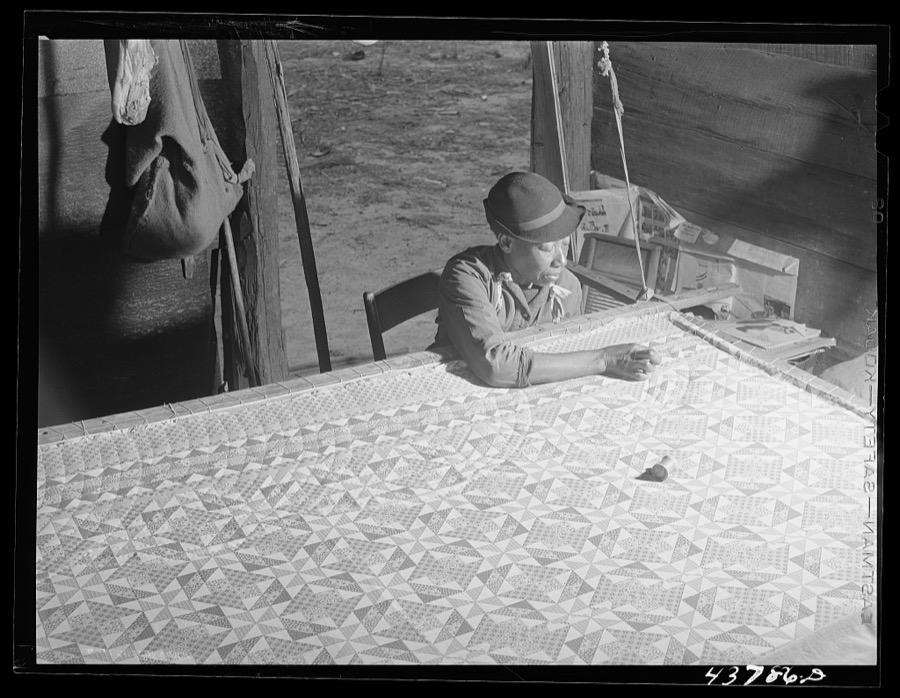 [Untitled photo, related to: A woman who has not yet found a place to move out of the Hinesville Army camp area working on a quilt in her smokehouse. Near Hinesville, Georgia