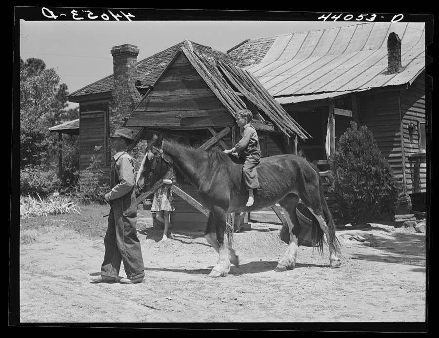 Colie Smith gets a ride on one of two horses owned by the Smith family. Carroll County, Georgia