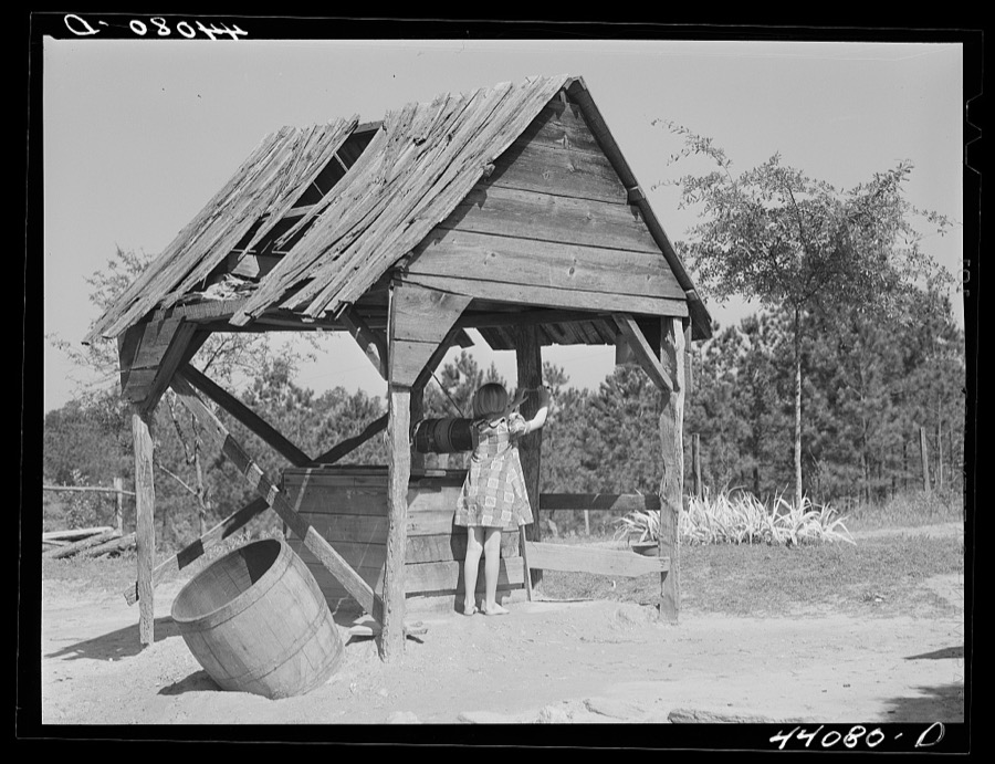 Iola Smith, drawing water from the well for which Mr. Smith, FSA (Farm Security Administration) borrower, built a cement foundation. Carroll County, Georgia
