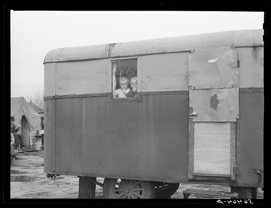 Children looking out of trailer window. Trailer where C.E. Children and family live in highway about three miles from Fort Benning. He is an auto mechanic and came up to Columbus, Georgia two weeks ago from Albany, Georgia and now works at Columbus Motor Company. They couldn't find any other place to live so had to get a trailer. They pay two dollars a week for space in W.T. Mullis' backyard. Never lived in a trailer before, don't like it, difficult with children and wet weather