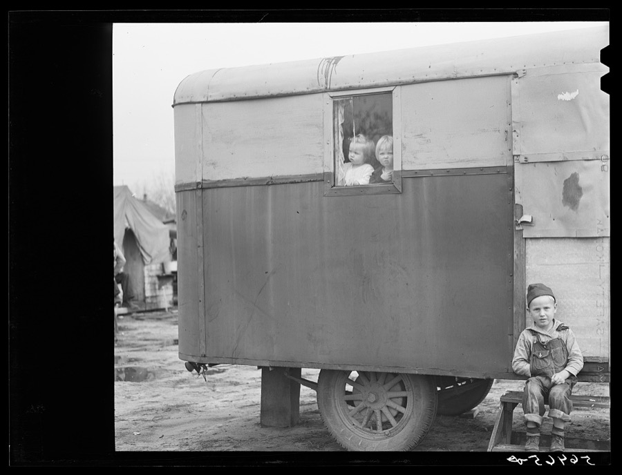 Children looking out of trailer window. Trailer where C.E. Children and family live in highway about three miles from Fort Benning. He is an auto mechanic and came up to Columbus, Georgia two weeks ago from Albany, Georgia and now works at Columbus Motor Company. They couldn't find any other place to live so had to get a trailer. They pay two dollars a week for space in W.T. Mullis' backyard. Never lived in a trailer before, don't like it, difficult with children and wet weather