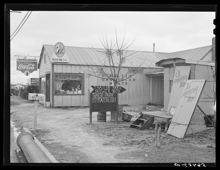 New sign in front of trailer park, and Itinerant photographer's trailer on highway near Fort Benning, Columbus, Georgia. Mr. W.T. Mullis owns property and grocery store and rents trailer space for two dollars a week to construction workers and Army men