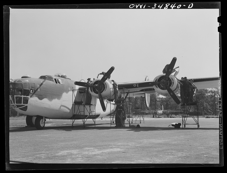 Warner Robins, Georgia. Air Service Command, Robins Field. Mechanics removing the cowling of one of the engines of a B-24 bomber