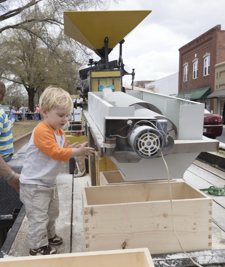 Ean Hoffmann tests a small, portable gristmill during Heritage Day in Louisville, a town in northeastern Georgia, named for French King Louis XVI in appreciation for French assistance to the colonists during the American Revolution