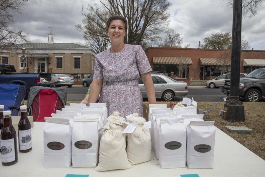 Melanie Unruh offers the ingredients for grits, a food made from corn that is ground into a coarse meal and then boiled, during Heritage Day n Louisville, a town in northeastern Georgia, named for French King Louis XVI in appreciation for French assistance to the colonists during the American Revolution