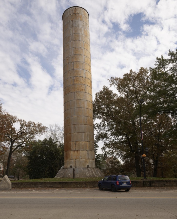 This looks, at first glance, like an industrial chimney, but it's a water tower, looking quite unlike the usual version that supports a large tank at the top