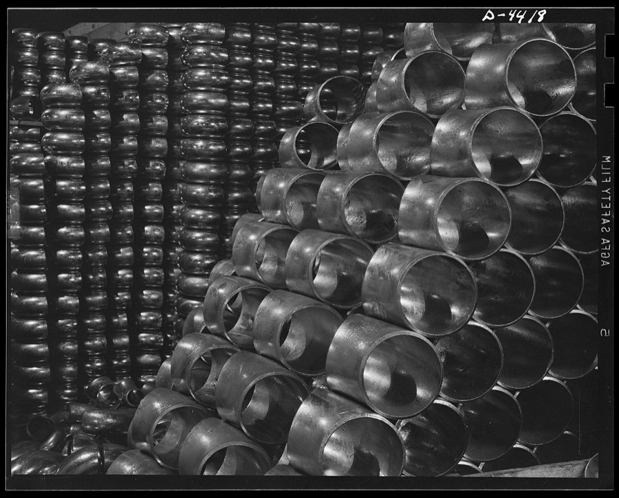 Production. Pipe fittings. Huge stocks of pipe fittings for Army equipment are being built up steadily in a big Midwest plant. The fittings are made by bending straight pipe, cutting off desired lengths from the curved sections and beveling edges for butt welding. Tube Turn Incorporated