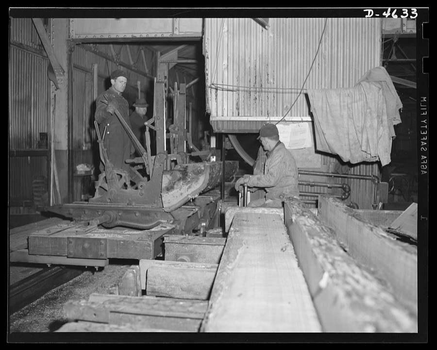 Production. Veneer for aircraft and other war essentials. Sawmill carriage in a large Midwest veneer plant cuts flitches, or slabs, from an oak log that will be used in making veneer for essential war purposes. The sawyer at the right controls the speed of the carriage and the thickness of the cut. Louisville, Kentucky