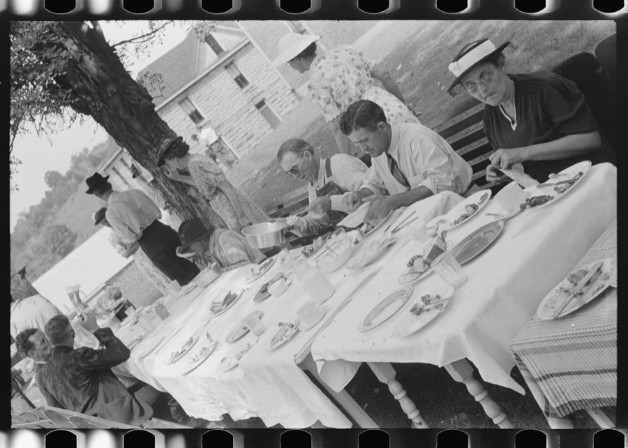 Mountaineers and farmers eating dinner served for benefit of the church in courthouse yard on court day. Campton, Wolfe County, Kentucky
