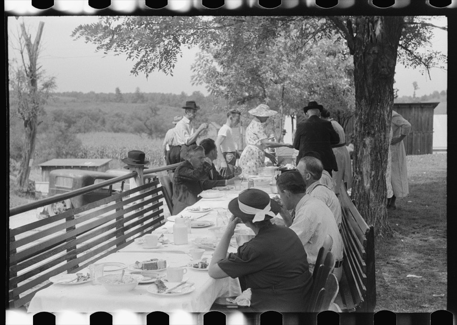 Mountaineers and farmers eating dinner served for benefit of the church in courthouse yard on court day. Campton, Wolfe County, Kentucky