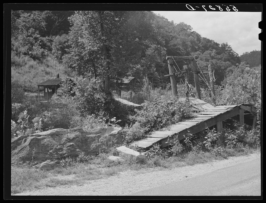 Swinging bridge crossing over creek from main road to post office and store. Ary, Kentucky