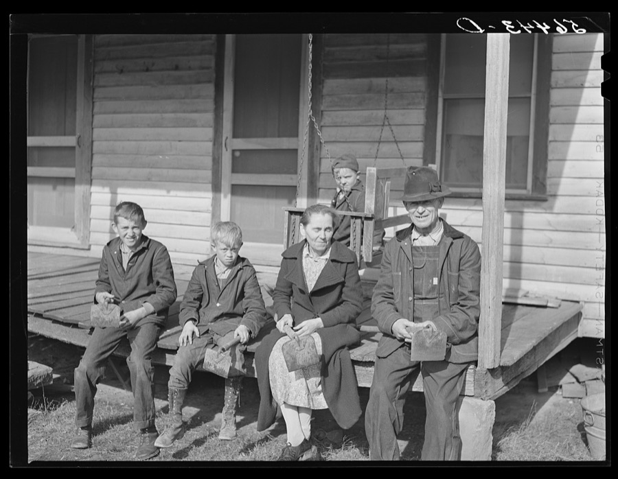 Dutton ("Dut") Calleb and his family with their homemade hoes on the porch of their home. Southern Appalachian Project near Barbourville, Knox County, Kentucky