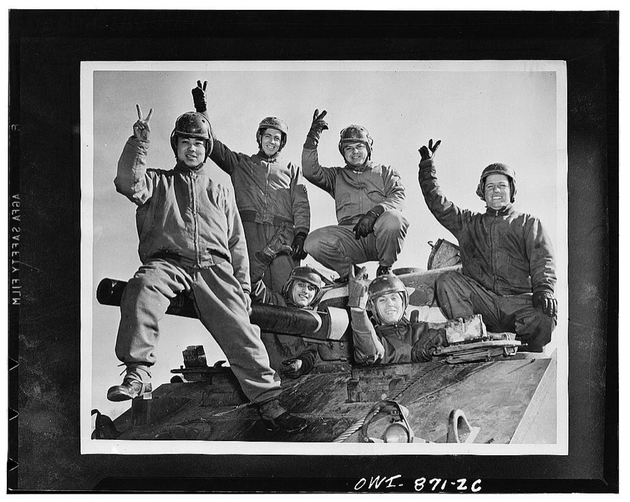 Fort Knox, Kentucky. Armoraiders symbolizing six nations atop a powerful medium tank: Private Richard Do Yee of China; Corporal Austin Chamberlain of England; Sergeant John Evans of Russia; Private Alexander Scourles, a revengeful Greek, and driver Henri de Charmont of the Fighting French. The tankman on the right is Private Johnny Smith of the United States