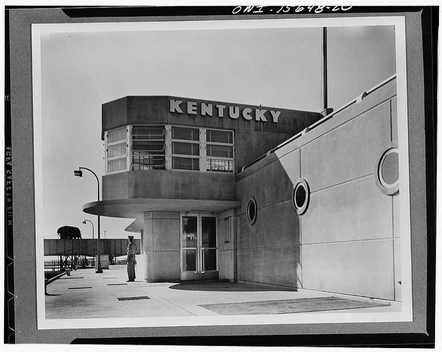 Dams under construction. Kentucky Dam, close to the mouth of the Tennessee River, will be one of the biggest projects of the Authority and will back the water up for a distance of 185 miles. It will be completed in 1944. This photograph shows a partial view of the lock operation building, with the commanding officer's work space, shaped somewhat like a control cabin in the foreground on the second floor. The near wing contains visitors' rest rooms while the lock switchboard is in the far wing, entered through the door in the foreground of the picture. Visitors are admitted to the various roof levels to watch the locking operation