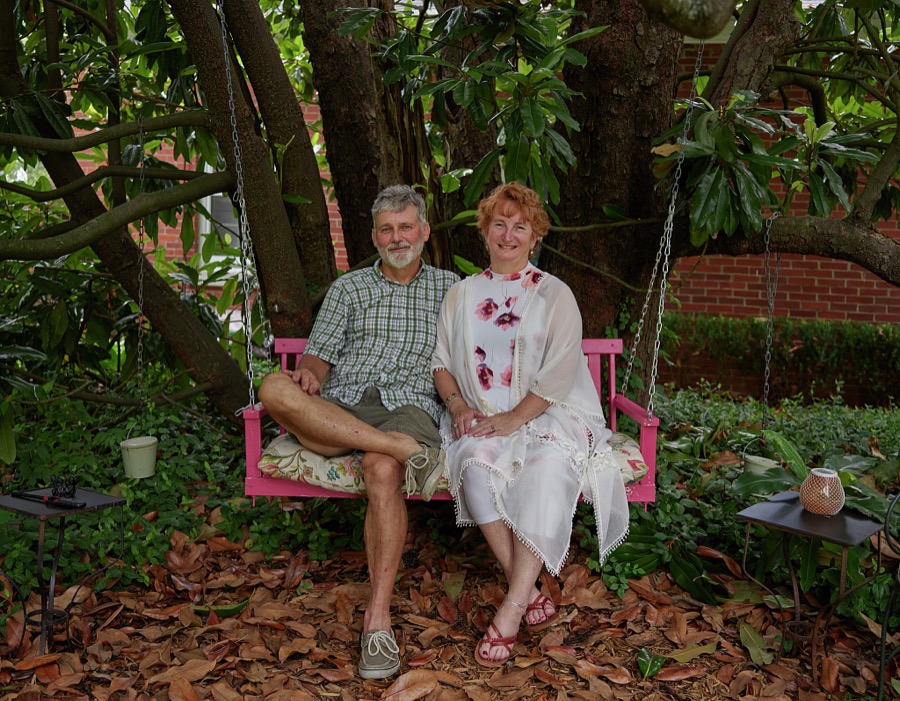 A suble mixture of hard work, cultivated leisure, and a gentle nature are trademarks of Kentuckians such as arborist Joel Dean Damron and his wife, local store manager Jill Giles, relaxing on a swing beneath a walnut grove beside their cottage home in tiny Midway, Kentucky, population 350 or so