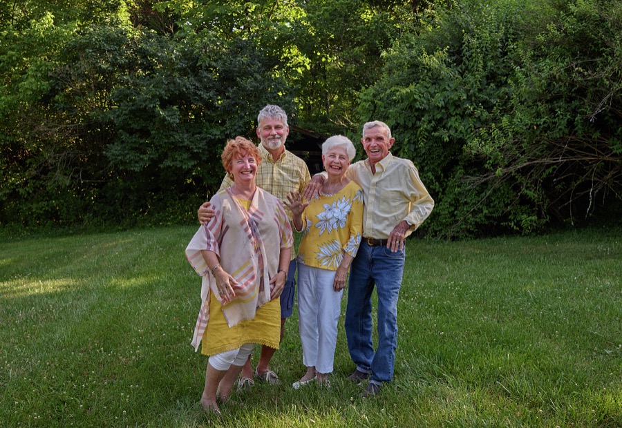 Four members of the Giles family catch the late-afternoon light near the remnants of a fallen barn amid the trees at their farm outside Carrollton, Kentucky
