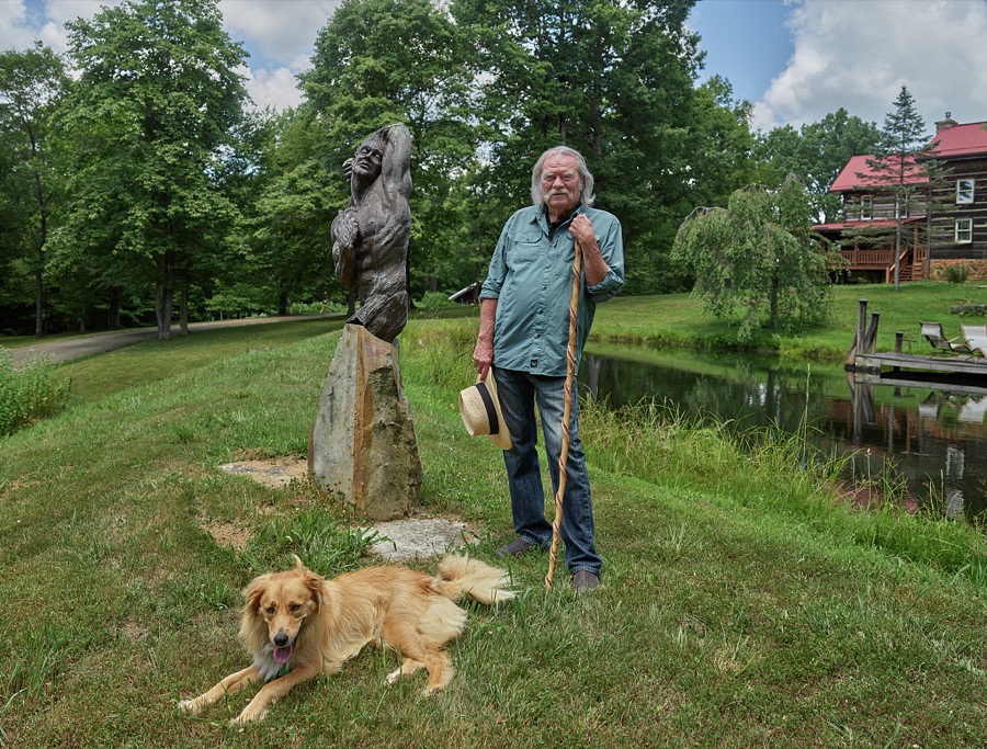 Celebrated sculptor Sam McKinney (and friend) relax near one of Mr. McKinney's creations in the Rowan County, Kentucky rural settlement of Elliottsville, near Morehead